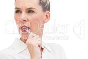 Businesswoman thinking with pen on mouth