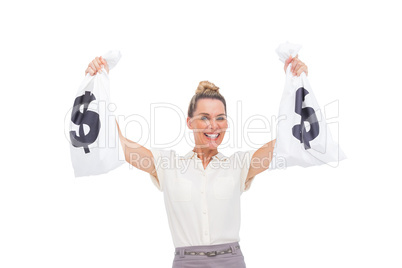 Smiling businesswoman carrying money bags