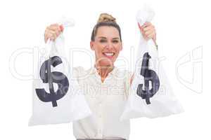 Smiling businesswoman carrying cash bags