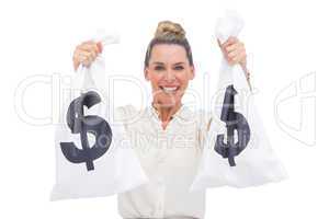 Cheerful businesswoman carrying cash bags