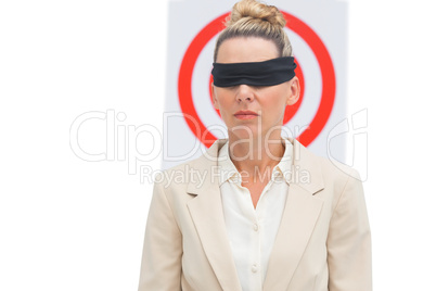 Businesswoman blindfolded in front of target