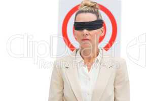 Businesswoman blindfolded in front of target