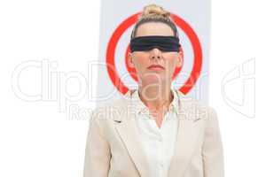 Businesswoman blindfolded and target behind