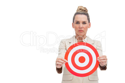 Frowning businesswoman holding target