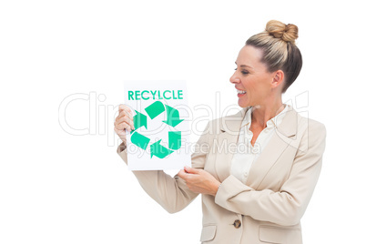 Businesswoman looking at recycling logo on paper