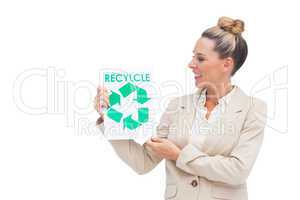 Businesswoman looking at recycling logo on paper