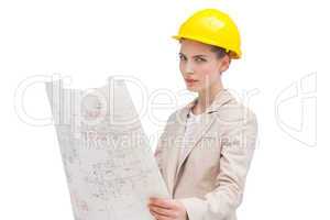 Pretty architect with helmet holding construction plan