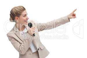 Businesswoman with microphone indicating something