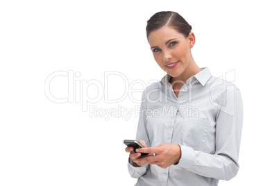 Smiling businesswoman sending text message