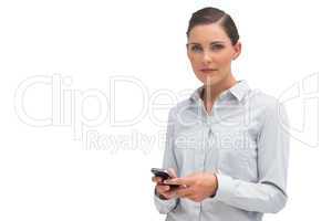 Serious businesswoman holding mobile phone