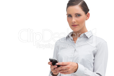 Serious businesswoman holding cellphone