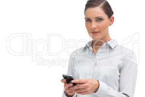 Serious businesswoman holding cellphone