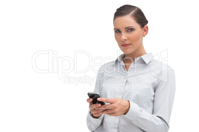 Unsmiling businesswoman holding cellphone