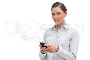 Unsmiling businesswoman holding cellphone