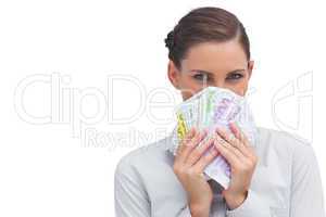 Businesswoman hiding behind money