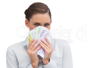 Businesswoman hiding behind money in her hands