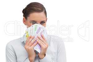 Businesswoman hiding behind money in her hands