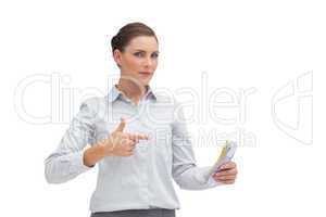 Businesswoman pointing to money in her hand