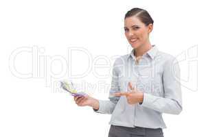 Happy businesswoman pointing to money in her hand