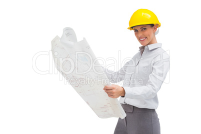 Architect reading blueprint with yellow helmet