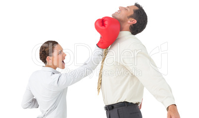 Businesswoman hitting a businessman with boxing gloves