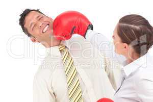 Businesswoman knocking out a businessman with boxing gloves