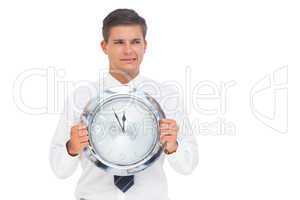 Anxious businessman holding a clock