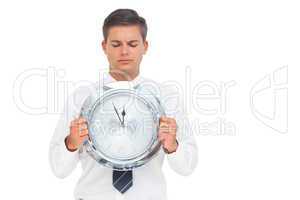 Businessman holding and looking at clock