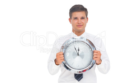 Nervous businessman holding a clock