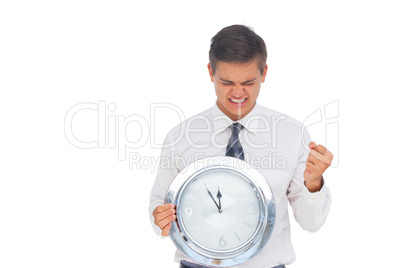 Excited businessman holding a clock