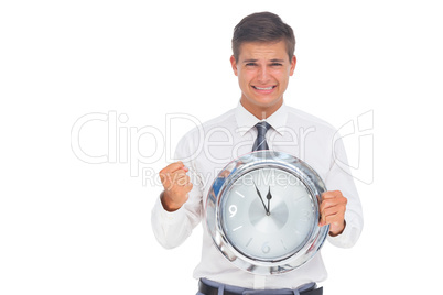 Fearful businessman holding and looking at clock