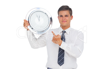 Businessman holding and showing a clock