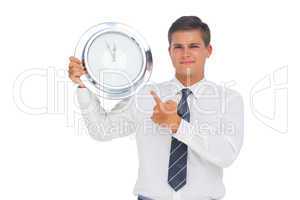 Businessman holding and showing a clock