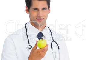 Doctor holding an apple and smiling