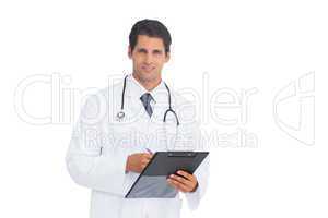 Doctor holding a clipboard and pen and smiling