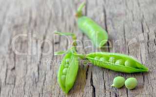 Fresh green peas on an old wooden background