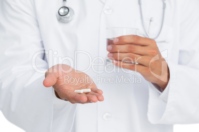 Doctor holding pills and glass of water