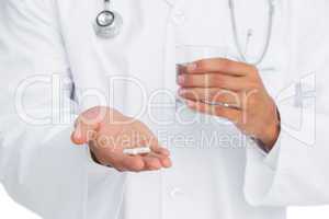 Doctor holding pills and glass of water