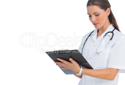 Serious nurse writing on clipboard