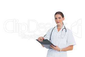 Nurse holding clipboard and looking at camera with large copy sp