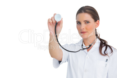 Stern nurse holding up stethoscope