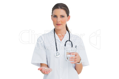 Smiling nurse holding medicine and glass of water