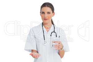 Smiling nurse holding medicine and glass of water