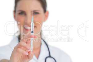 Happy nurse holding a syringe up