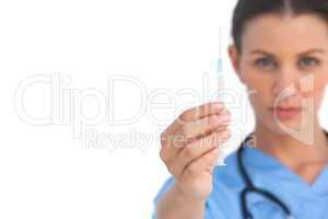 Serious surgeon holding up a syringe