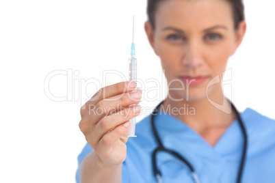 Serious surgeon holding a syringe Serious surgeon holding a syringe