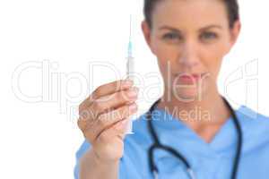 Serious surgeon holding a syringe