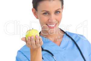 Happy surgeon holding an apple and smiling