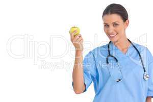 Happy surgeon holding an apple and smiling at camera