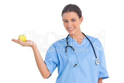 Happy surgeon holding an apple